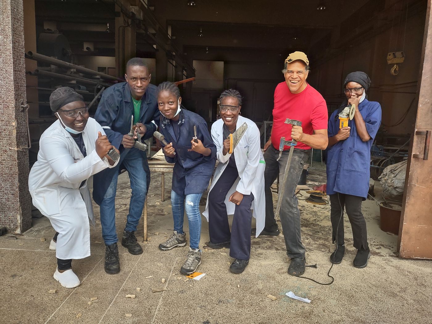 Builders and trainees holding tools in the workshop